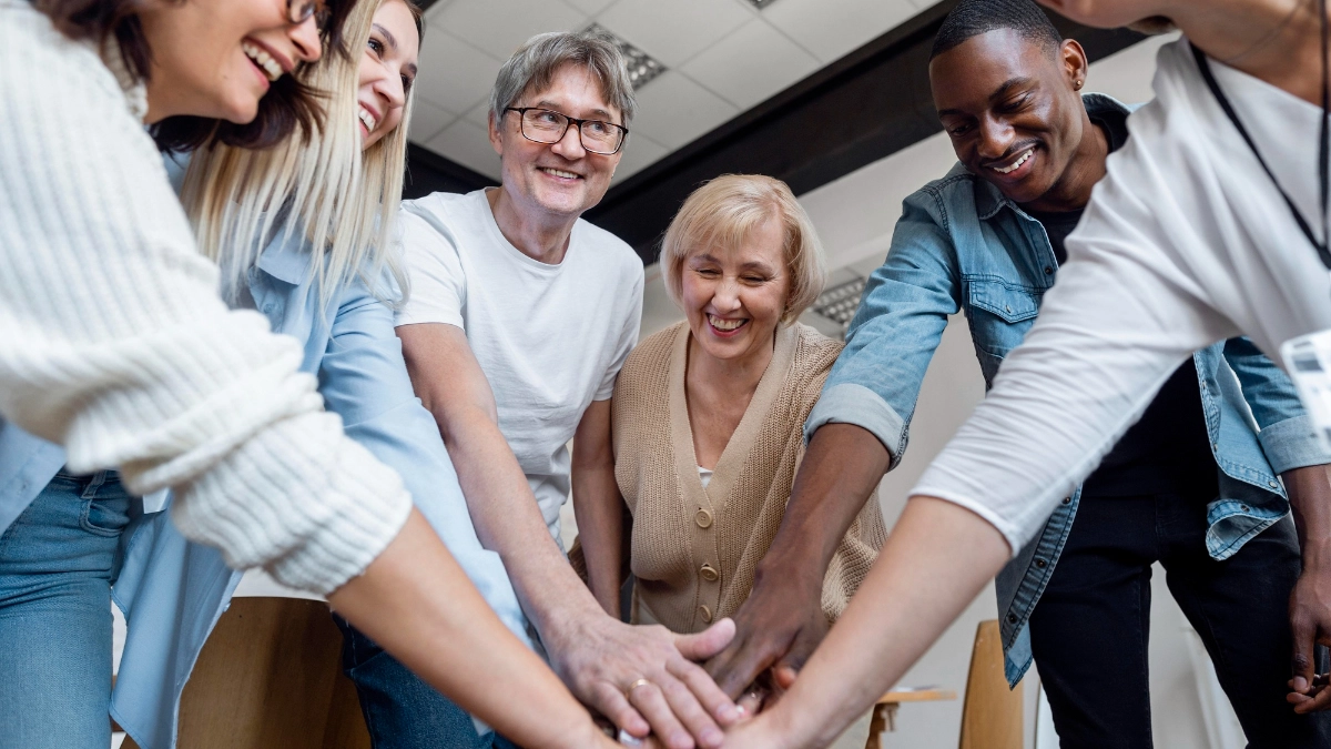 A group of people with their hands meeting in the middle